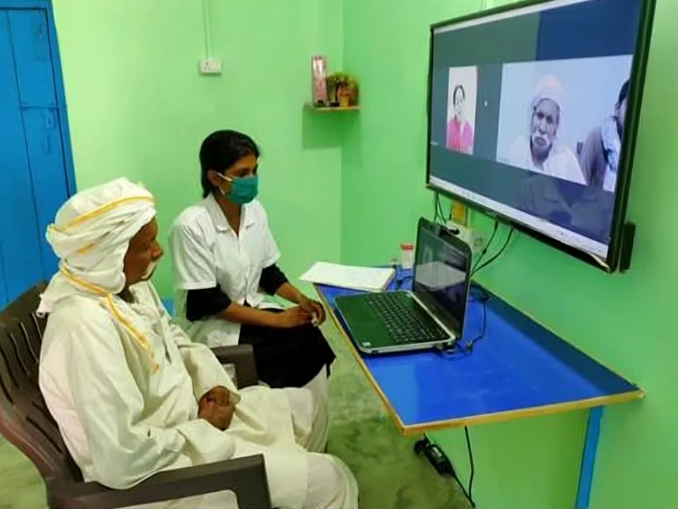 A patient speaks with a specialist on screen at a telemedicine unit